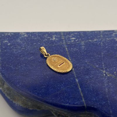 a close up of a gold coin sitting on top of a blue stone