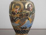 a vase with a painting on it sitting on a table