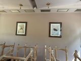 a room with a bunch of wooden chairs and a painting on the wall