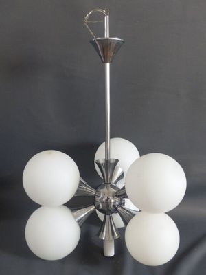 une image d'un lustre avec des boules de verre blanches suspendues au plafond