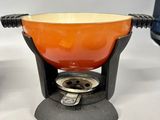 an orange bowl sitting on top of a stove