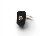 une image représentant une bague ornée d'une pierre noire et d'un diamant blanc