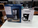 two boxes of coffee makers on a table in a store