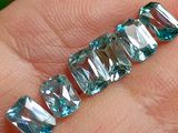 une personne tenant un morceau de cristal bleu dans la main