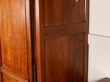 a wooden armoire and a chest of drawers in a room