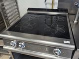 a stove in a commercial kitchen with a lot of cooking equipment