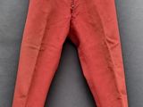 un pantalon rouge suspendu à une corde à linge
