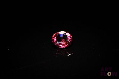 gros plan d'un diamant rose sur une surface noire