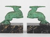paire de sculptures vertes représentant un oiseau et un autre oiseau, posées sur un socle en marbre