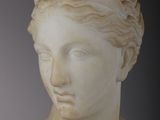 marble bust of a woman with braided hair and a headband