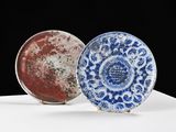 une paire d'assiettes bleues et blanches posées sur une surface blanche, sur fond noir