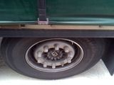 a close up of a flat tire on a green truck