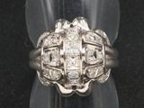 un gros plan d'une bague en diamant posée sur un présentoir transparent