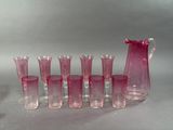 plein de verres roses et un pichet sur la table