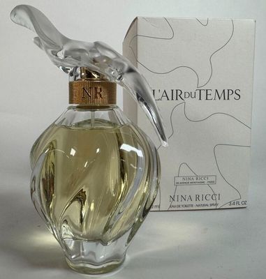 un flacon de parfum orné d'un oiseau, à côté d'une boîte