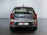 the back end of a silver car in a room with a white wall