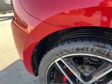a close up of a red car ' s tire on the street