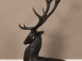 a close up of a statue of a deer on a wooden floor