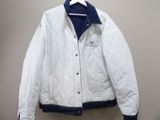 white and blue jacket hanging on a hanger on a wall