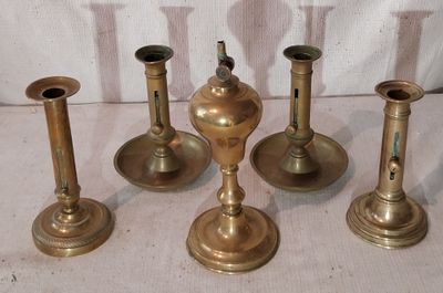 cinq bougeoirs en laiton posés sur une table