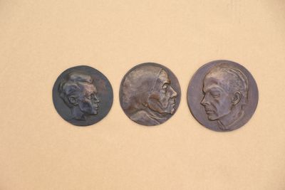 trois médaillons en bronze représentant deux hommes et une femme