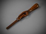 an old wooden stick with a wooden handle on a gray surface