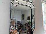 a statue of a man holding a mirror in a room
