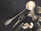 a lot of silver spoons and other silverware on a black table