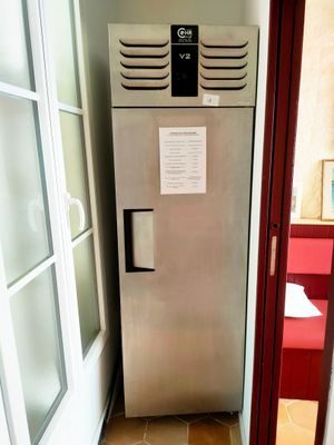 un réfrigérateur sur lequel est accrochée une affiche, dans un coin de la pièce