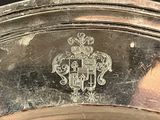 a close up of a silver plate with a coat of arms on it
