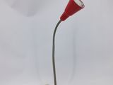 une lampe de bureau rouge surmontée d'un cordon blanc
