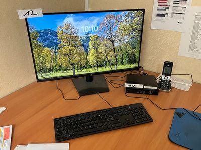 un bureau d'ordinateur sur lequel se trouvent un écran, un clavier, une souris et d'autres objets