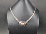 un collier orné d'une perle autour du cou d'un mannequin