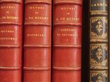 several books are lined up on a shelf in a library