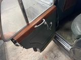 someone is opening the door of an old car with their shoes on the ground