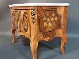 a small wooden chest with a marble top