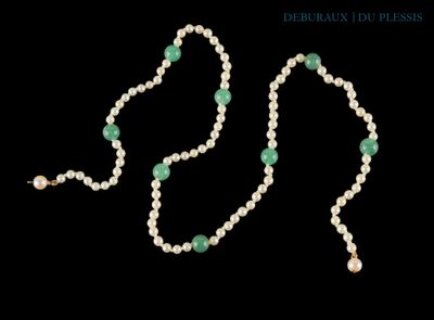 un gros plan sur un collier composé de perles et d'une perle verte