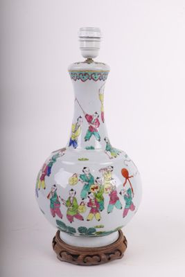 un vase blanc orné d'une peinture, posé sur un socle en bois