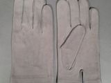 pair of white leather gloves sitting on top of a table