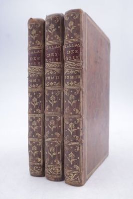 three old books sitting on top of each other on a white surface