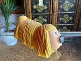 a yellow dog statue on a glass table next to a potted plant