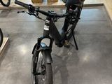 un vélo garé dans une pièce où se trouvent des cartons