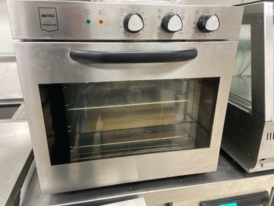 a silver oven sitting on top of a counter in a kitchen