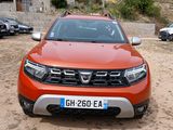 a red car that is parked in the dirt