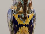 a blue and yellow vase sitting on a wooden table