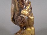 bronze statue of a woman sitting on a shell with a flower