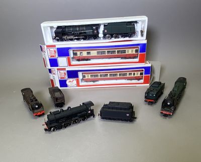 quatre petits trains miniatures posés les uns à côté des autres sur une table