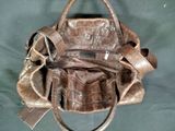 a brown purse that is sitting on a green cloth
