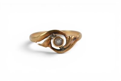 gros plan d'une bague en or avec une pierre au milieu