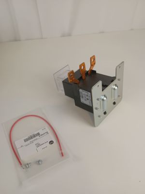 a close up of a small switch with a red cord on a white surface